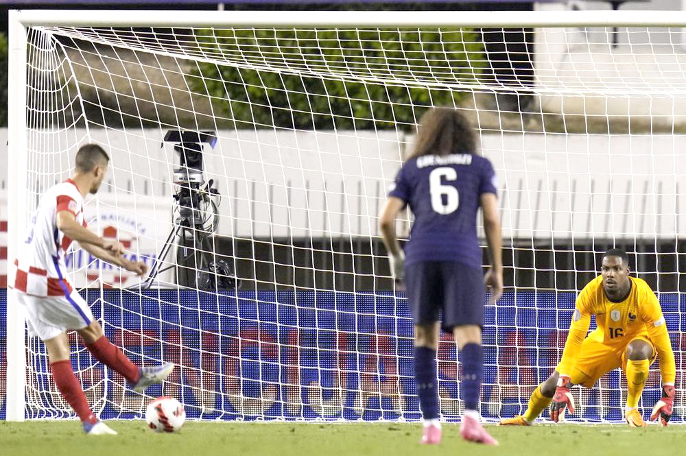 Croatia's Andrej Kramaric, left, scores his side's opening goal from penalty during the UEFA Nations League soccer match between Croatia and France at the Poljud stadium, in Split, Croatia, Monday, June 6, 2022. (AP Photo/Darko Bandic)